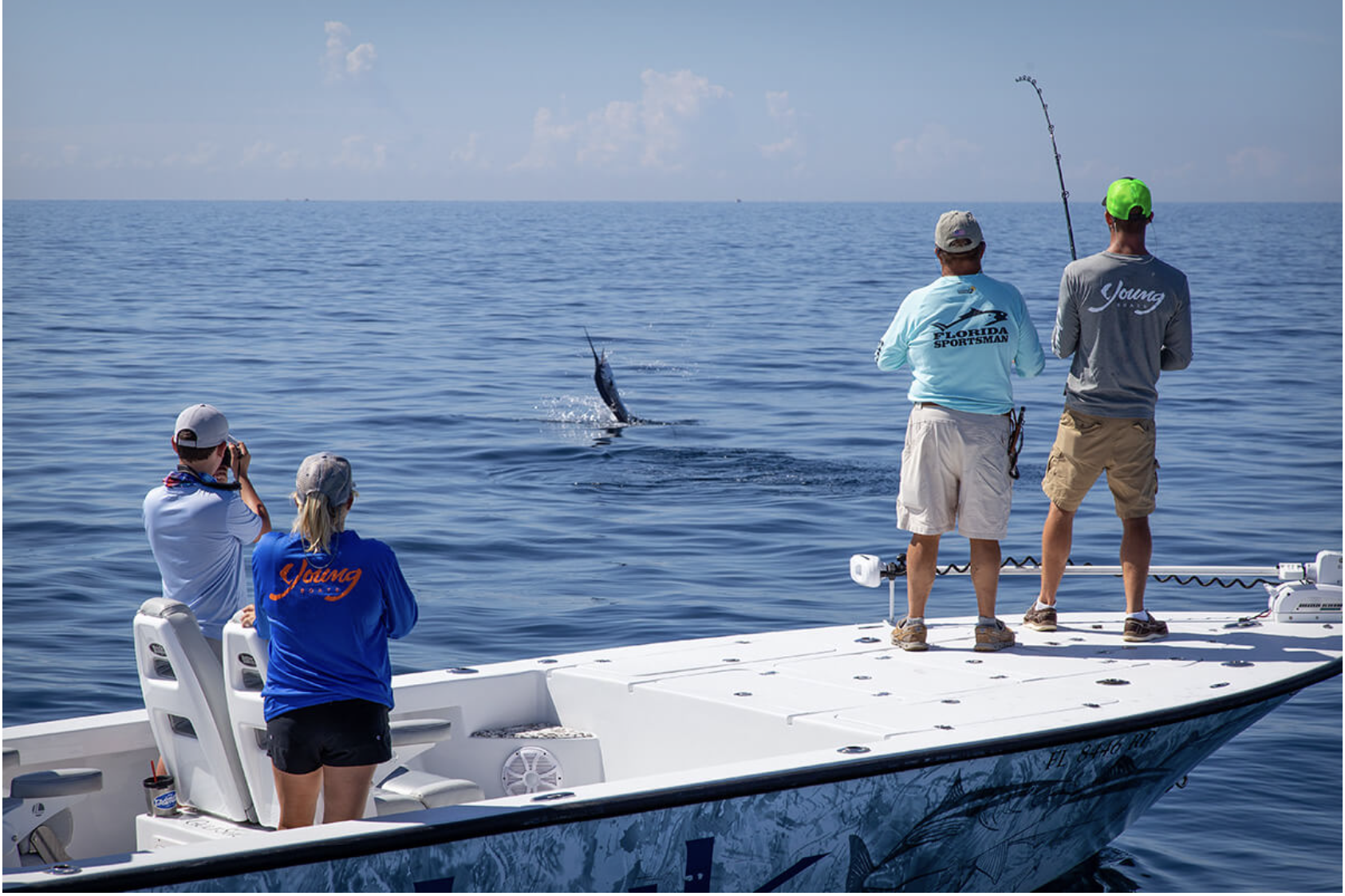 Anglers watching a marlin jump on a Miami sport fishing charter